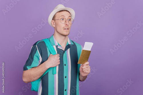 Profile portrait of curious charming geek tourist guy hold tickets on purple background