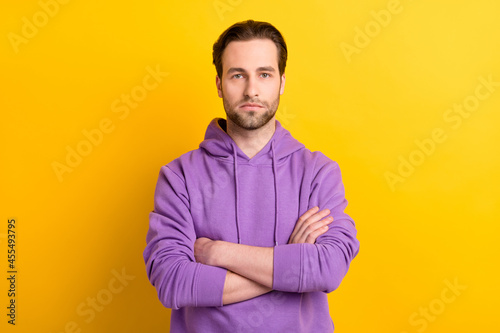 Photo of young handsome man serious confident crossed hands wear hoodie isolated over yellow color background