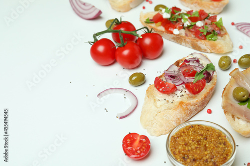 Delicious italian snacks bruschetta and ingredients on white background