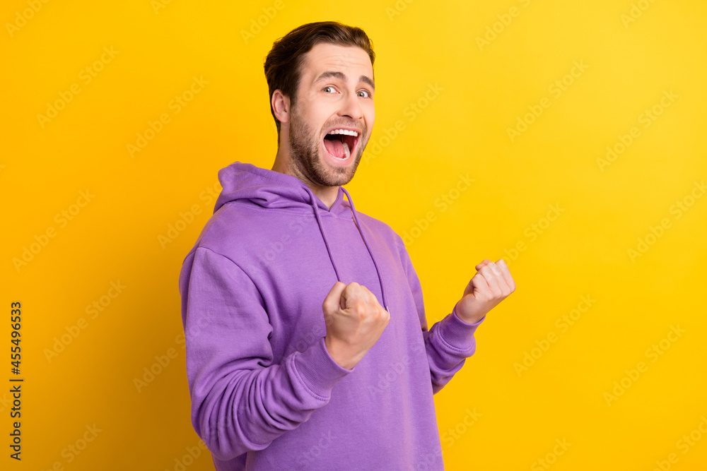 Photo of cheerful positive guy yell goal rejoice celebrate victory wear violet sweatshirt isolated yellow color background Photo of cheerful positive guy yell goal rejoice celebrate victory wear violet sweatshirt isolated yellow color background