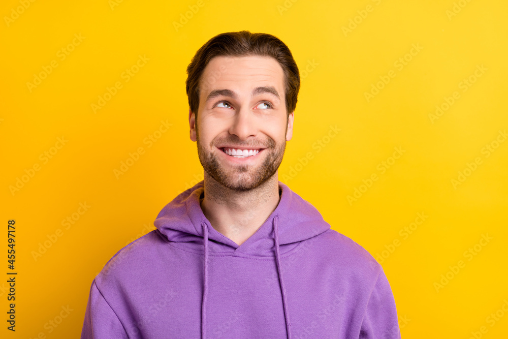 Photo of handsome bearded curious guy look up empty space wear purple hoodie isolated yellow color background Photo of handsome bearded curious guy look up empty space wear purple hoodie isolated yellow color background