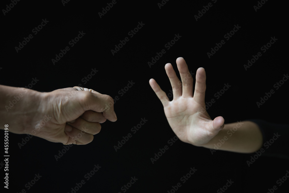 Violent young man threatening his girlfriend with his fist. Domestic violence concept, stop violence against Women. Violent young man threatening his girlfriend with his fist. Domestic violence concept, stop violence against Women.