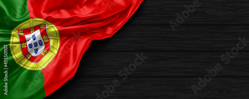 Close Up of Portugal flag on the black wooden background 3D render