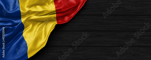Close Up of Romania flag on the black wooden background 3D render