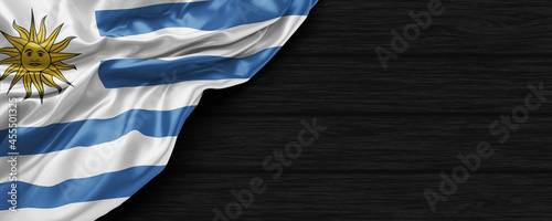 Close Up of Uruguay flag on the black wooden background 3D render