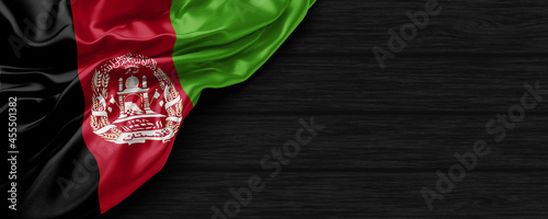 Close Up of Afganistan flag on the black wooden background 3D render