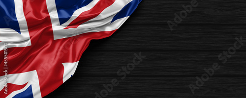 Close Up of United Kingdom flag on the black wooden background 3D render