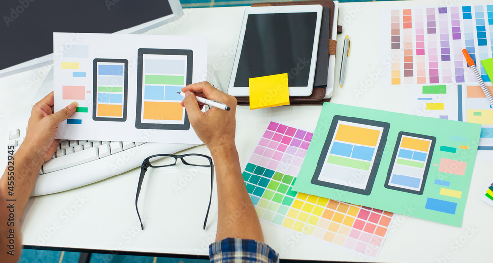 Mobile app designers work at their desks and design application interface functions.