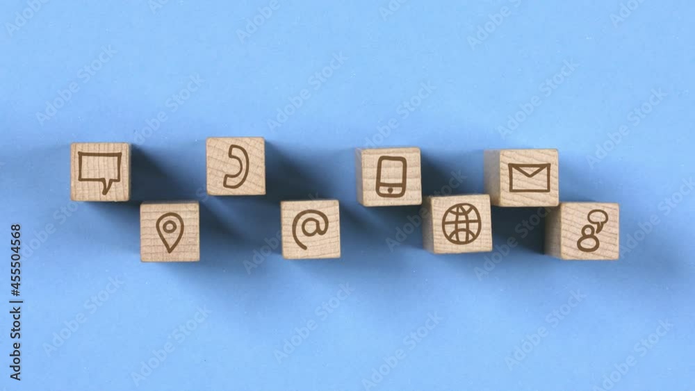 Wooden blocks with Mail, Speech Bubble, Receiver, Globe and Phone icons moving to the center. Concept of Communication and Innovation. Seamless looping. Blue background. High quality 4k video Wooden blocks with Mail, Speech Bubble, Receiver, Globe and Phone icons moving to the center. Concept of Communication and Innovation. Seamless looping. Blue background. High quality 4k video
