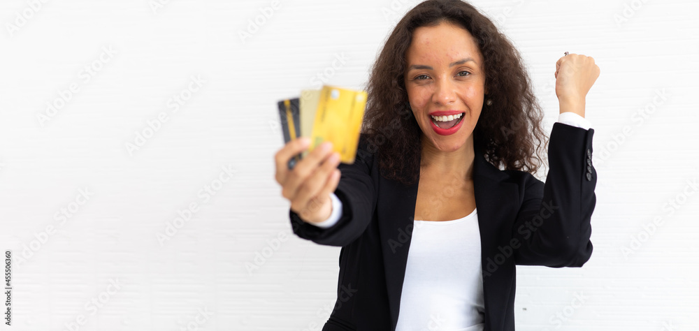 portrait cheerful excited latin business woman curly hair model holding credit card on hand. portrait cheerful excited latin business woman curly hair model holding credit card on hand.