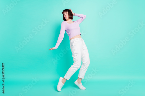 Full length body size photo woman surprised amazed dancing at party looking copyspace isolated vibrant teal color background