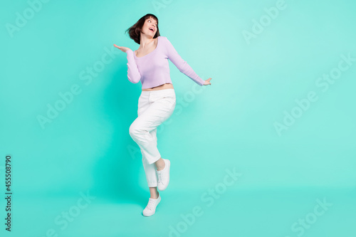 Full length body size photo woman in casual outfit dancing at party smiling looking copyspace isolated vivid teal color background