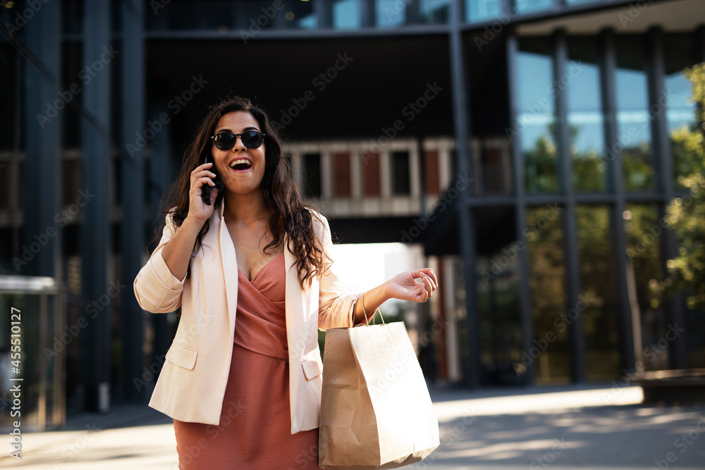 Young beautiful businesswoman talking to the phone. Female manager using the phone while walking through the city