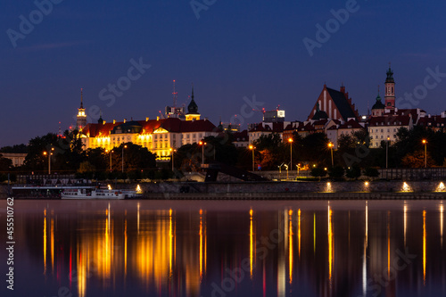 Illuminated Warsaw Old Town landscape with the Royal Castle, Cathedral and medieval buildings, night view with reflections in calm Vistula river, Poland. © Cleop6atra