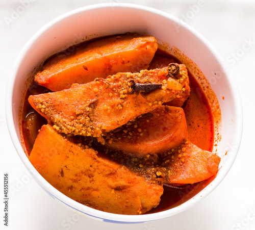 Dum Aloo or Potato gravy or subzi,a popular Indian Kashmiri dish. Has sliced potatoes immersed in thick gravy made of herbs,spices.Served in parties,wedding.Overhead view isolated on white background. photo