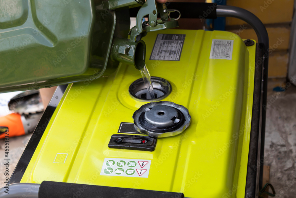 Fototapeta premium Gasoline is poured into the generator tank from a canister.