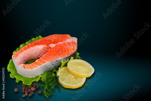 Fresh raw fish Fillets on a plate with lemon and parsley.