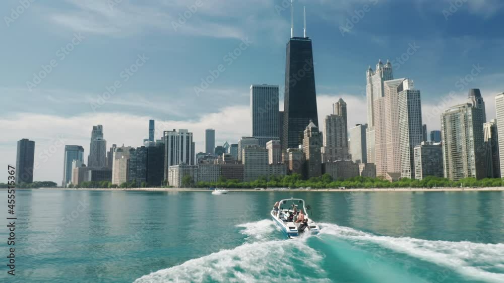 Water sports tourism, leisure activity, summer vacation 4K. Aerial view of Chicago skyline and white sailing boat in Michigan lake blue green still waters with downtown Chicago on motion background.