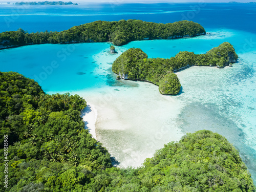 Aerial view of jungle covered limestone islands in Palau with lagoon and beach