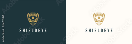 Abstract Security Logo. Gold Shield Linear Geometric Sunburst with Eyeball inside isolated on Double Background. Usable for Business and Technology Logos. Flat Vector Logo Design Template Element.