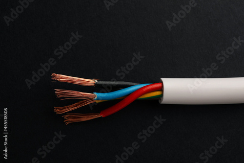 Cable with stripped wires on black background, closeup