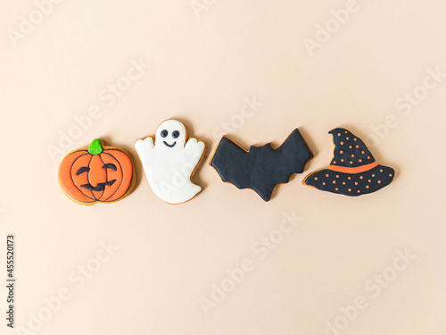 Various Halloween gingerbread cookies - Jack O'Lantern, ghost, bat and black hat on beige background. photo