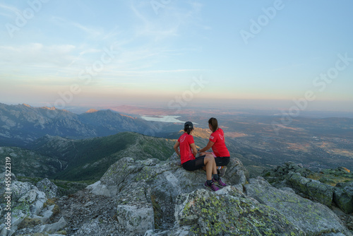 Dos chicas observando el paisaje en lo alto del pico de la maliciosa