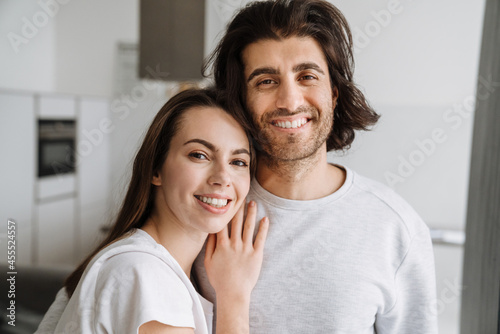 Young multiracial couple smiling while hugging together