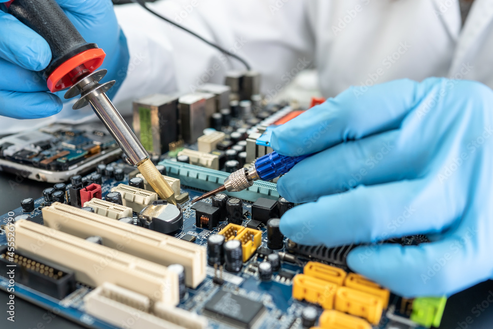technician repairing inside of hard disk by soldering iron. Integrated Circuit. the concept of data, hardware, technician and technology. technician repairing inside of hard disk by soldering iron. Integrated Circuit. the concept of data, hardware, technician and technology.