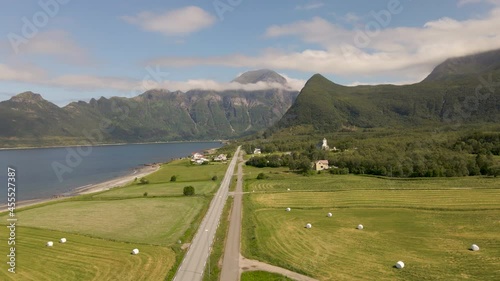 Farm Landscape Of Village Of Mevik With Rural Road And Mevik Chapel In Gildeskal, Norway. Hognakken Mountain In Distant Background. aerial photo