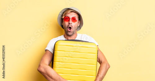 expressive crazy bearded man on hollidays holding a suitcase photo