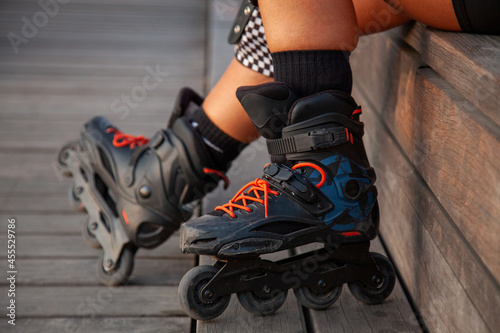 Mujer con accesorios de roller. Botas de patinaje en línea. Piernas de mujer con los patines puestos.  photo