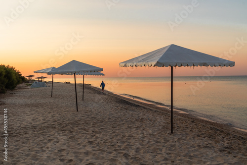 Beach umbrellas on the beach of the Black Sea during sunrise.