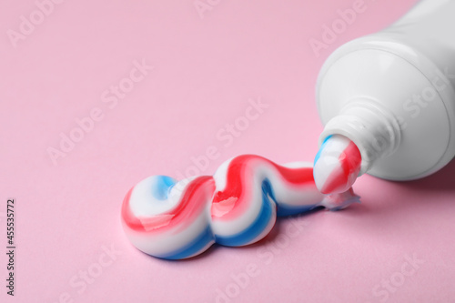 Quadro su tela Tube with squeezed out toothpaste on pink background, closeup