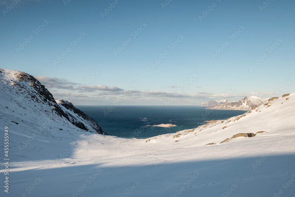 Snow covered mountain range and arctic ocean on winter in sunny day