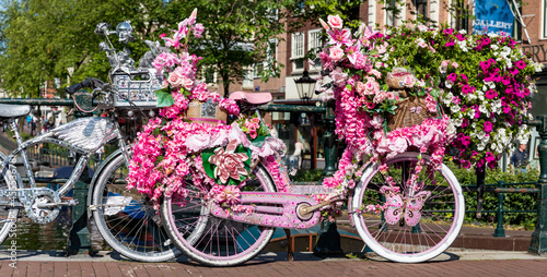 Brücke in Amsterdam mit Fahrrädern, kunstvoll geschmückt mit Blumen bei den Grachten, Holland.