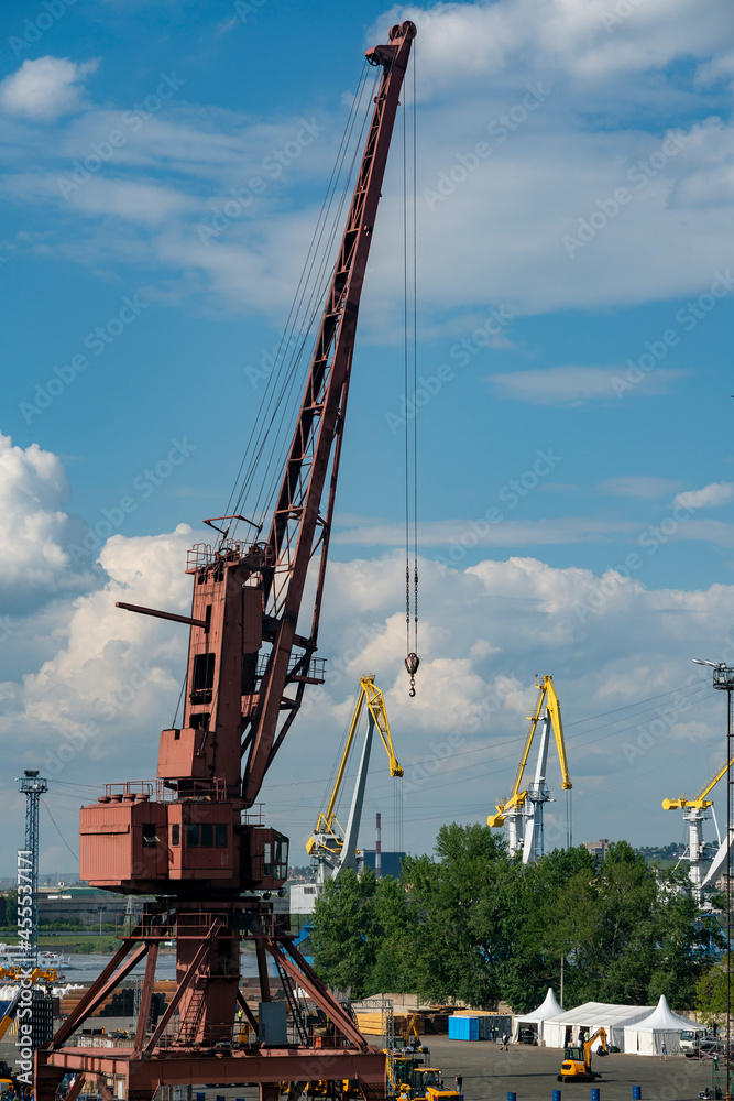Large red harbor crane on the background of an industrial city. Large red harbor crane on the background of an industrial city.