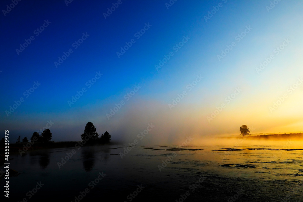 Morning Sunrise with Trees and River Blue Sky and Glowing Mist