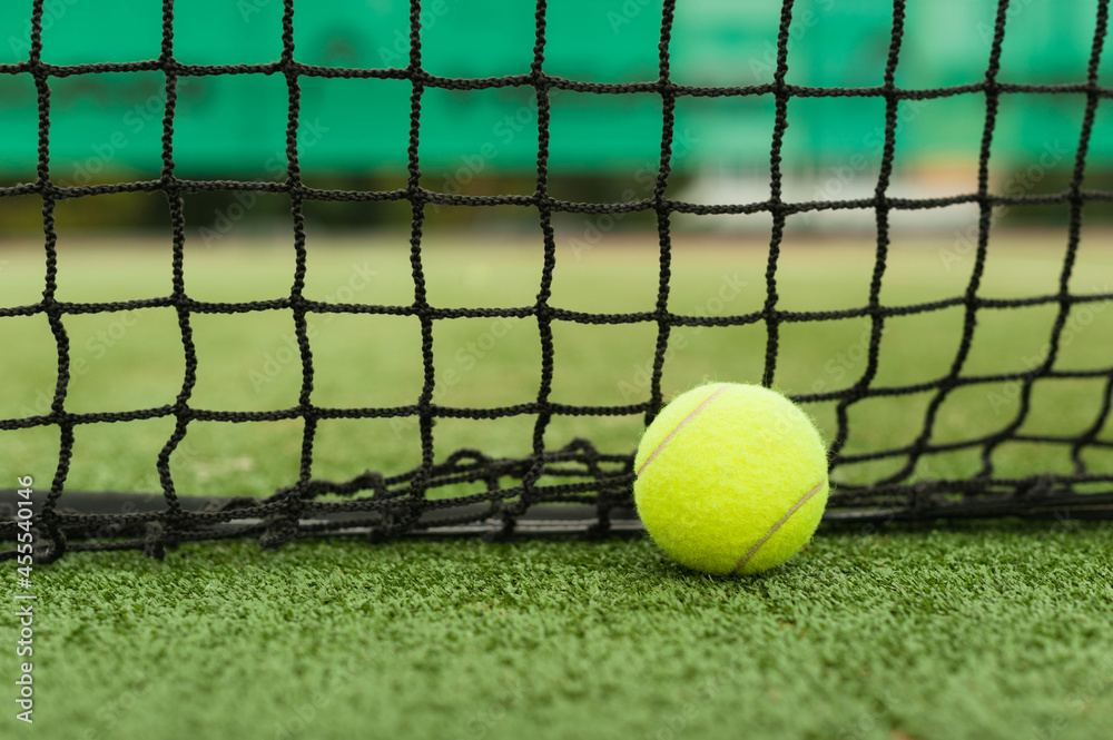 tennis ball on the background of the net lies after the fall. Photo with copy space.
