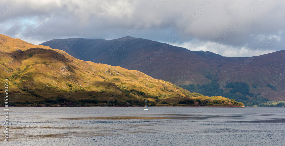A solo yacht glides up Loch Eil after passing the Corran narrows against a spectacular highland backdrop.