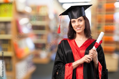 happy young female student with diploma at graduation hat