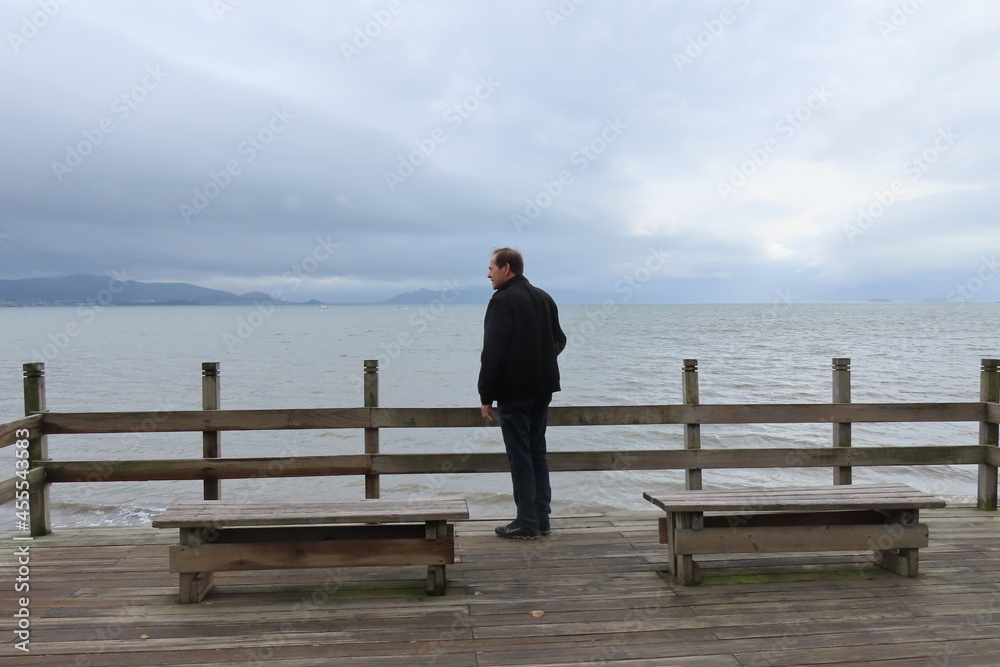 man sitting on a pier
