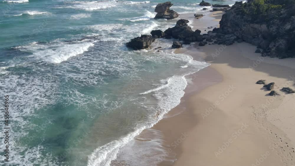 Drone stationary in sky as waves roll into shore Drone stationary in sky as waves roll into shore