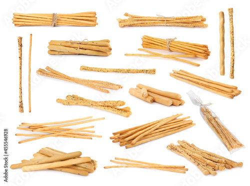 Set with delicious crispy grissini sticks on white background