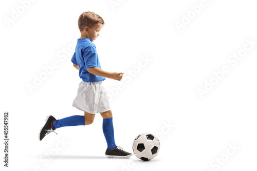 Full length profile shot of a boy running with soccer ball