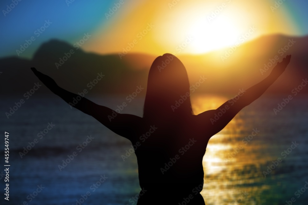 Happy woman rise hand up on sunset sky at beach and island background.
