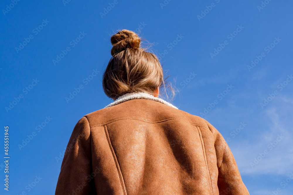 A woman in a leather sheepskin coat looks at the sky A woman in a leather sheepskin coat looks at the sky