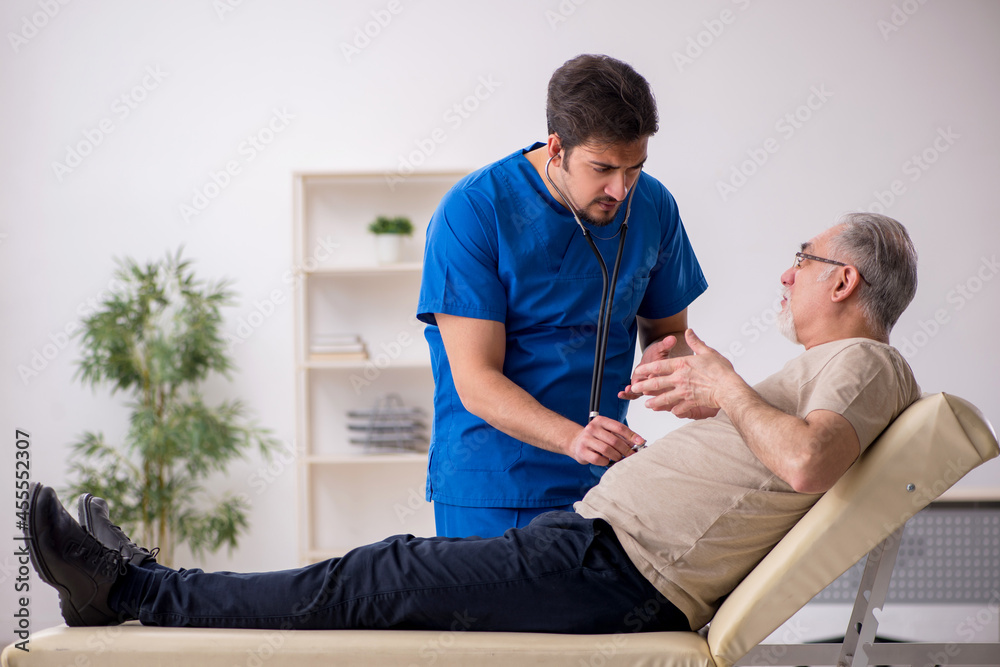 Old male patient visting young male doctor Old male patient visting young male doctor