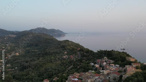 Aerial drone view over western coast and Pelekas village at sunset. Island of Corfu, Greece. photo