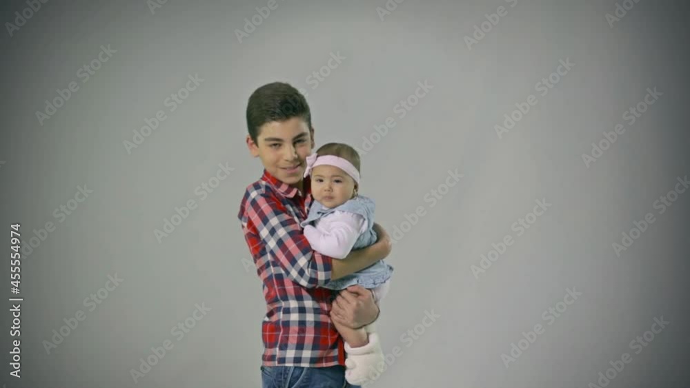 Good looking and loving Brother holding little baby Sister hugging , kissing . Adorable . Happy lifestyle kids . Good looking and loving Brother holding little baby Sister hugging , kissing . Adorable . Happy lifestyle kids .